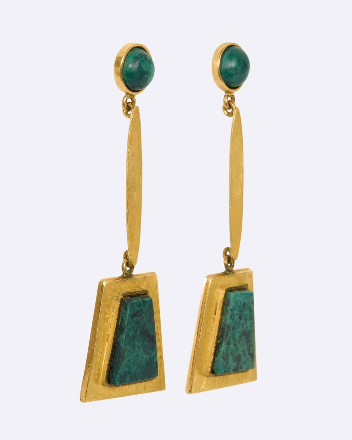 A yellow gold pair of trapezoid drop earrings with malachite. View from the side.