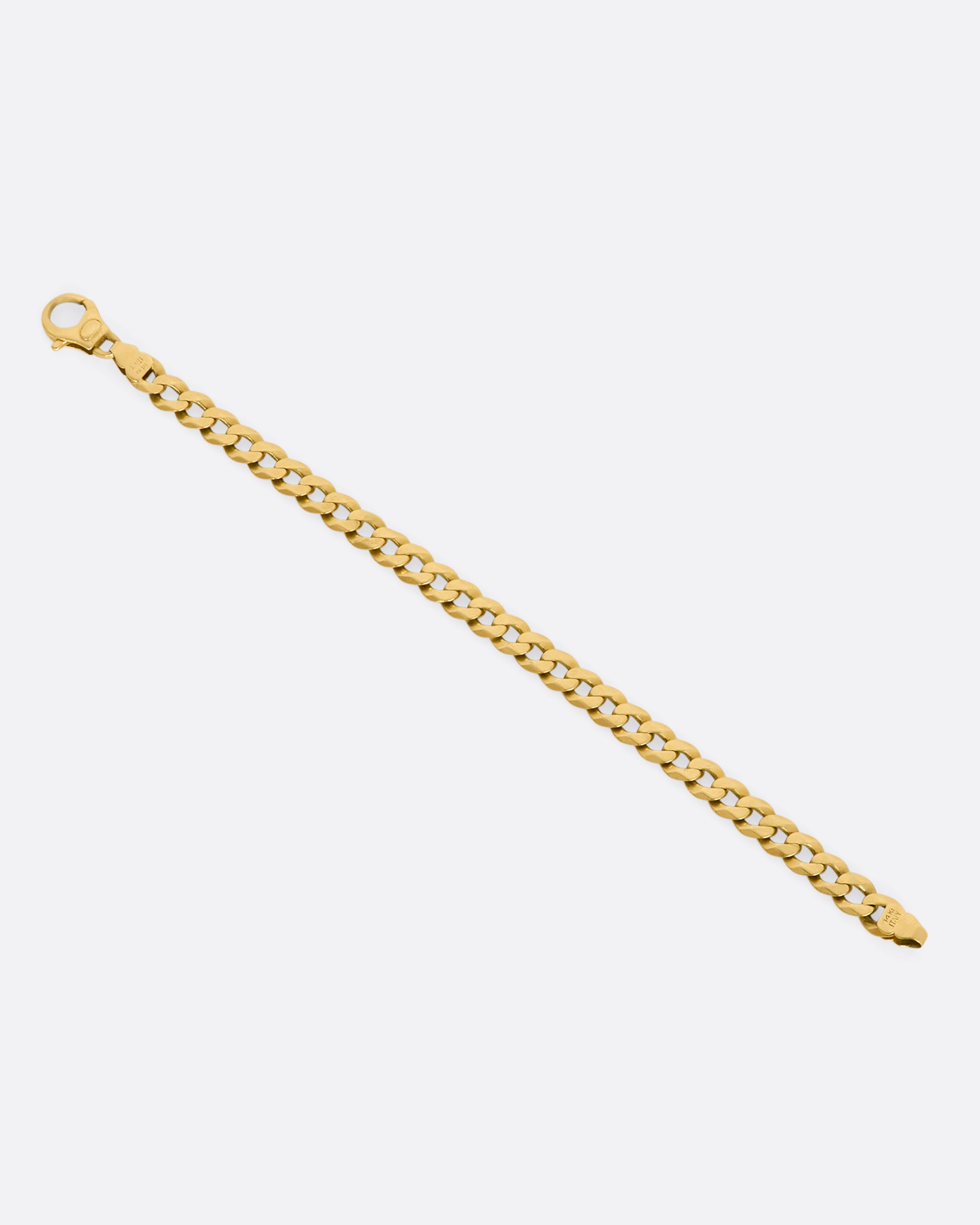 A yellow gold flat curb chain bracelet. View of the back from above, laying flat and open.