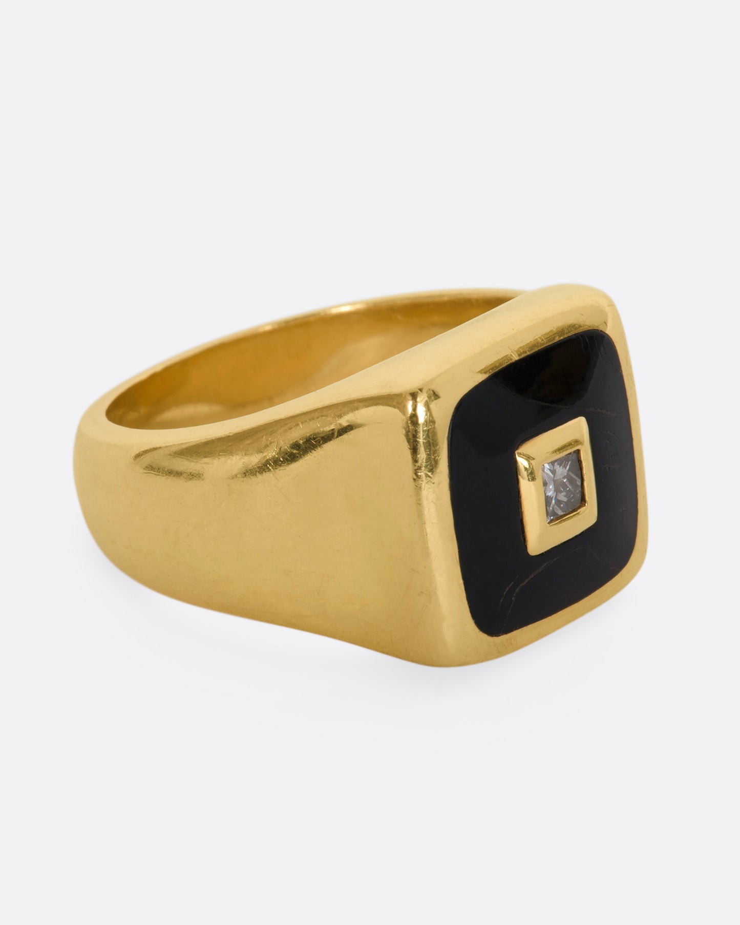 A yellow gold signet ring with onyx inlay and a princess cut diamond. View from the alternate side.