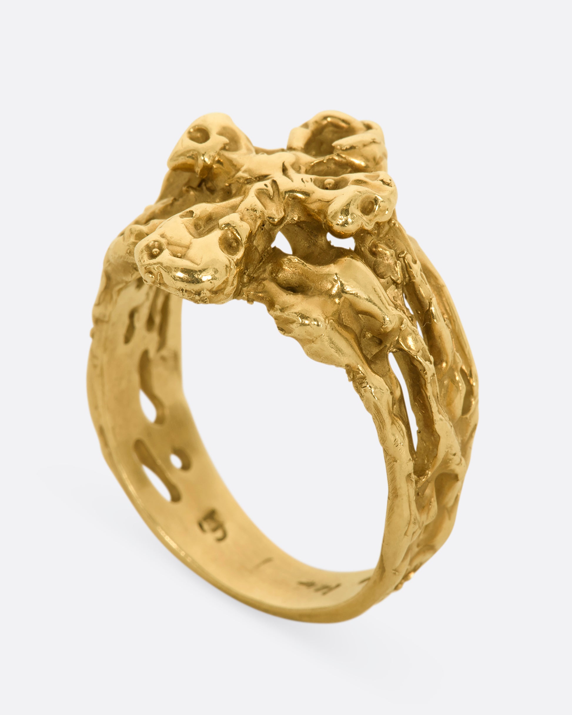 A yellow gold nugget ring with and ankh symbol. View from the side, standing up.