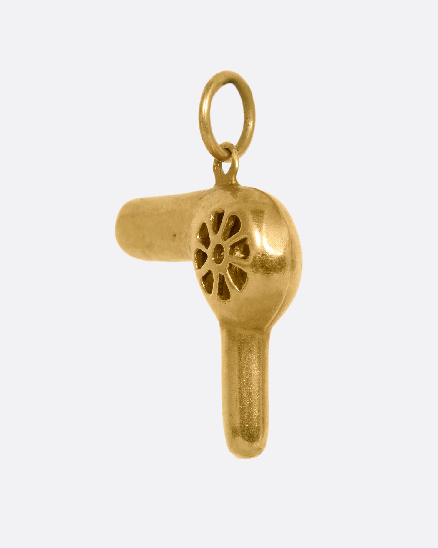 A three dimensional yellow gold hair dryer charm or pendant. View from the side.