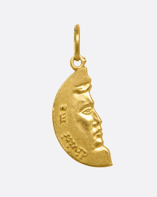 A yellow gold half circle pendant with a face profile. View from the front.