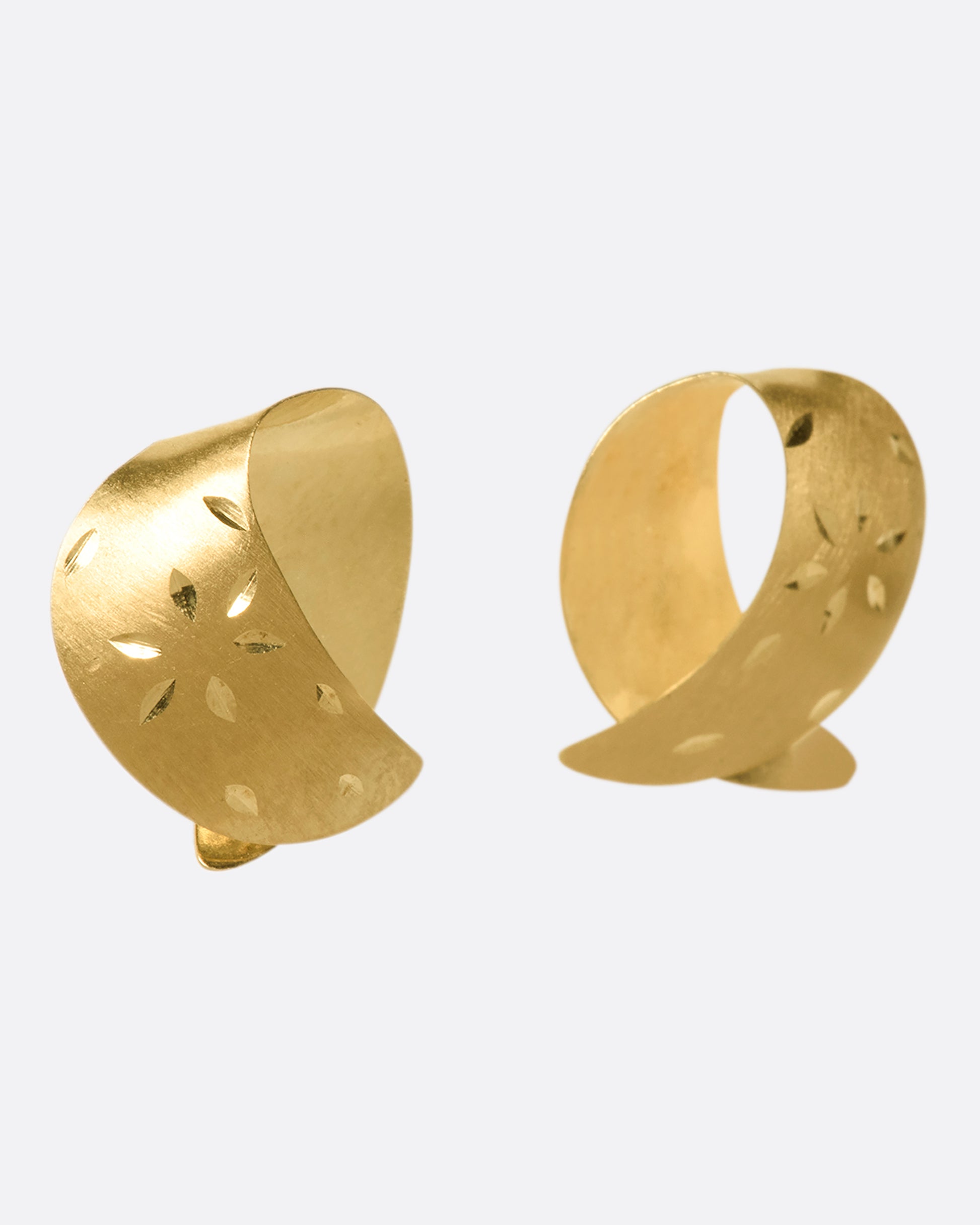 These vintage lightweight, folded studs are made of both matte and polished 14K gold. They're engraved with floral details that pick up light as you move.