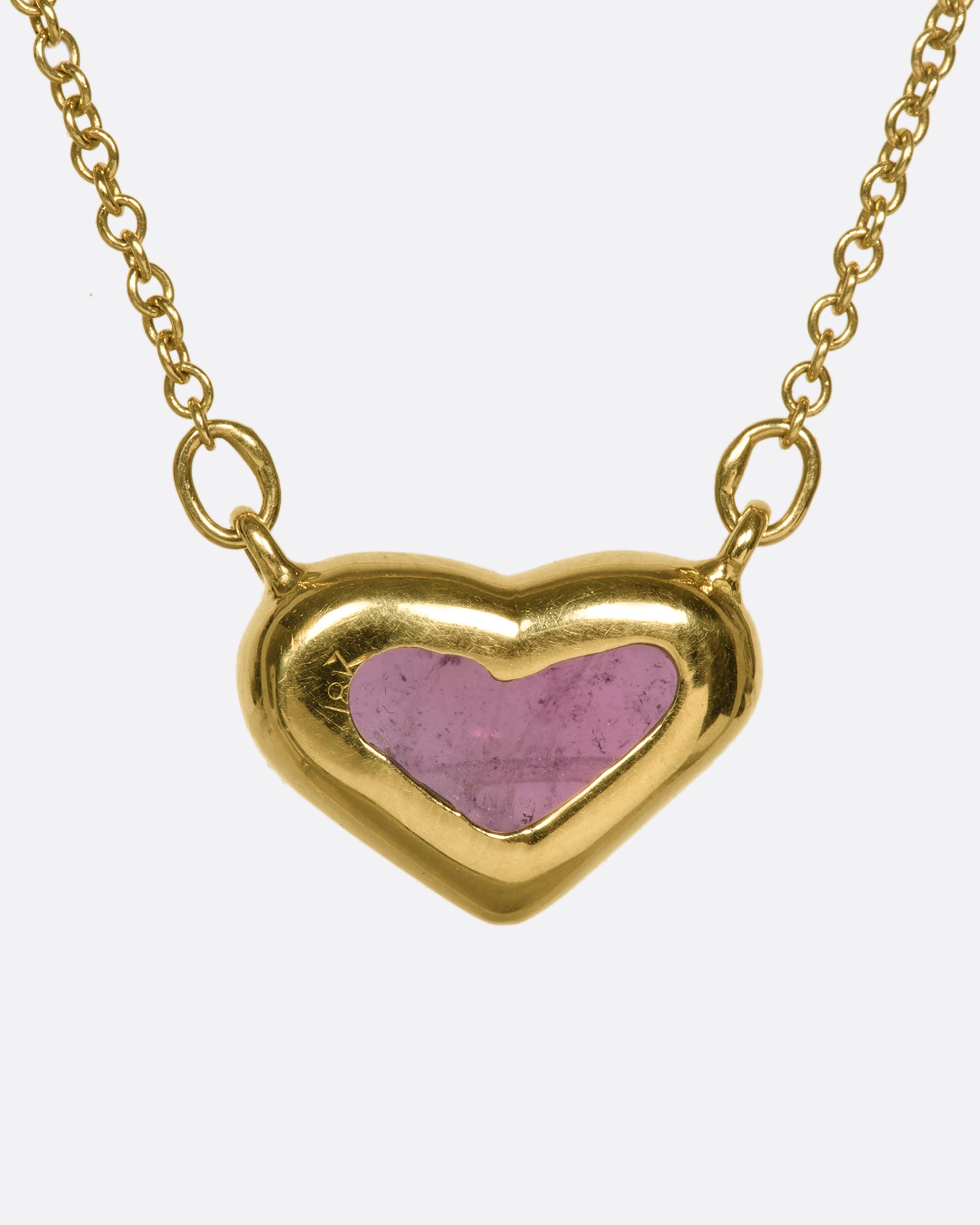 This 18k gold chain holds a unique watermelon rubellite heart encased in a gold bezel setting