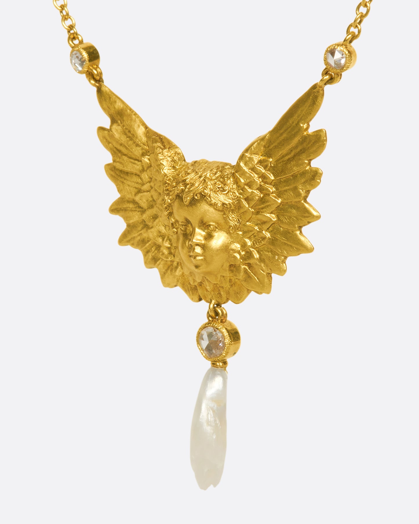 A show-stopping 18k gold cherub necklace with three bezel-set rose-cut white diamonds and a natural pearl drop