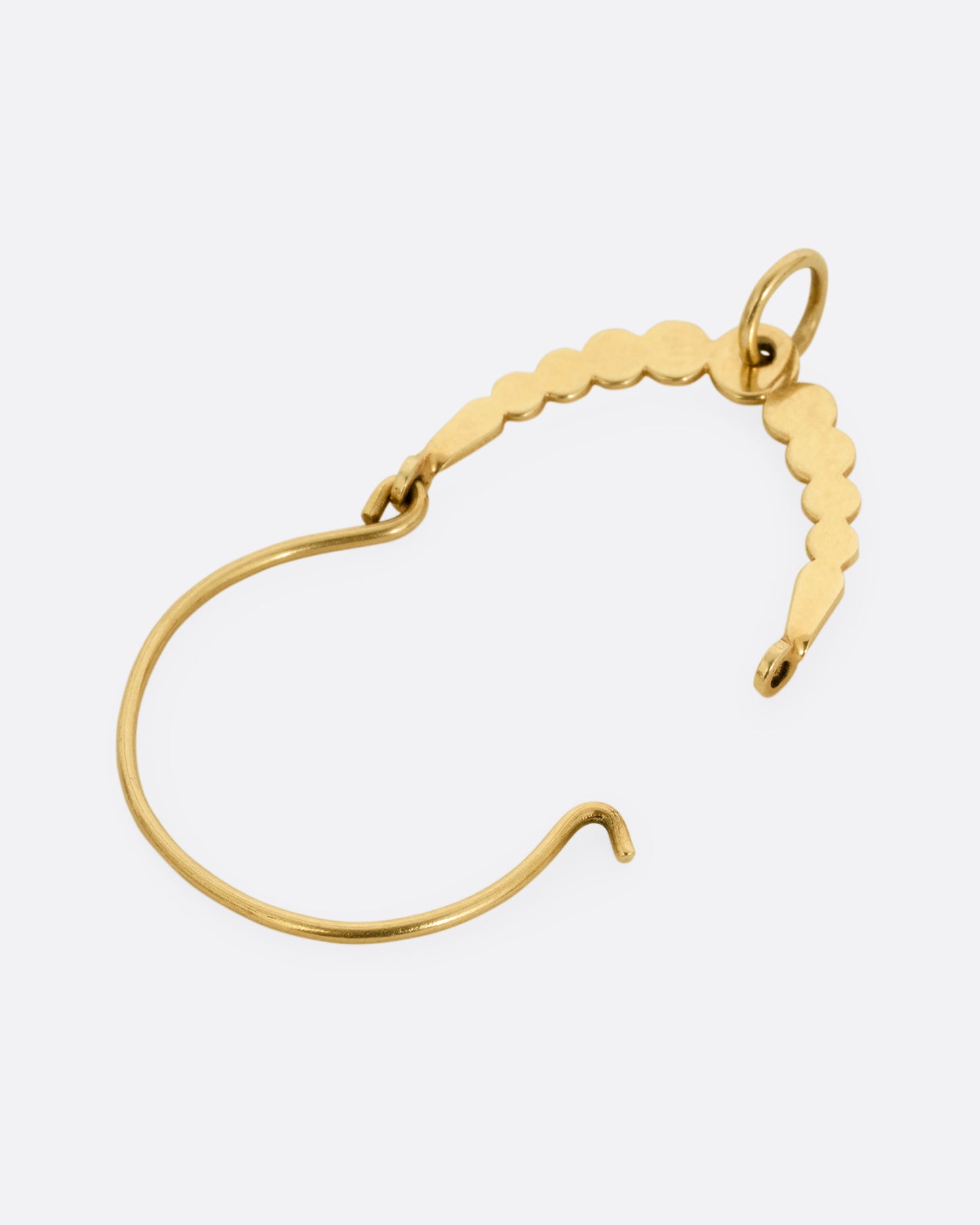 A yellow gold bubbly arching charm holder, shown open lying flat.
