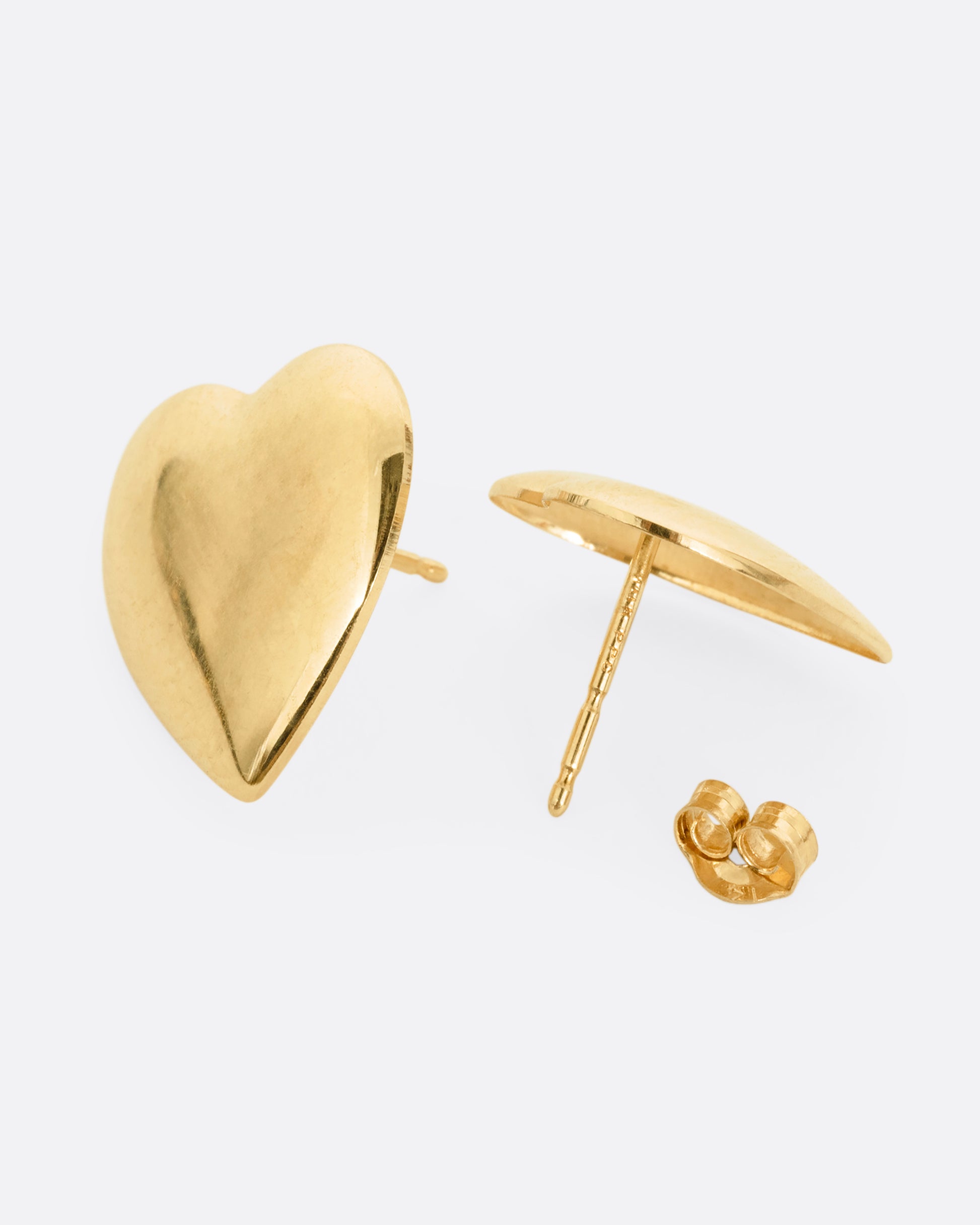 A pair of yellow gold heart-shaped stud earrings. One earring is shown from the front, the other open from the back.