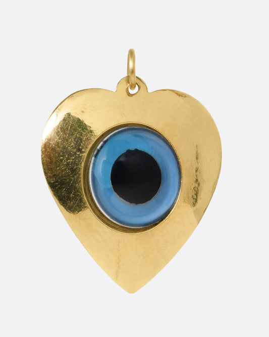 A yellow gold heart shaped charm with an evil eye at its center. Shown from the front.
