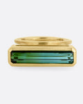 A yellow gold ring with a bi-color tourmaline in a suspended bezel setting   with open shoulders, shown from the front.