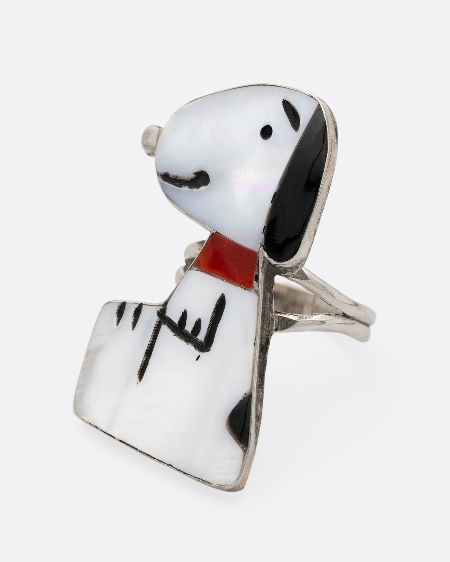 A silver Zunitoon style Snoopy ring made of iridescent mother of pearl and coral inlay. Shown from the side.