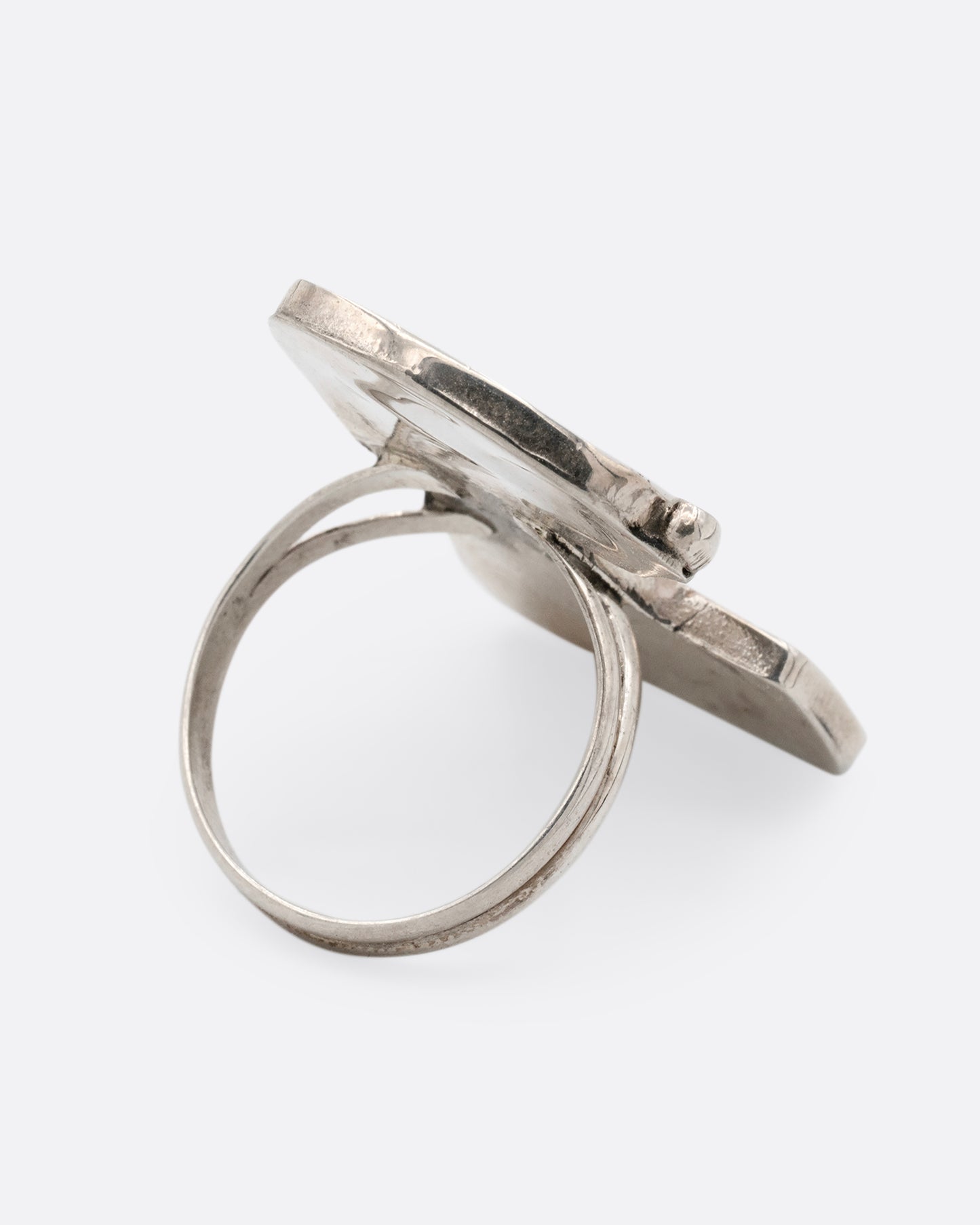 A silver Zunitoon style Snoopy ring made of iridescent mother of pearl and coral inlay. Shown from the back.