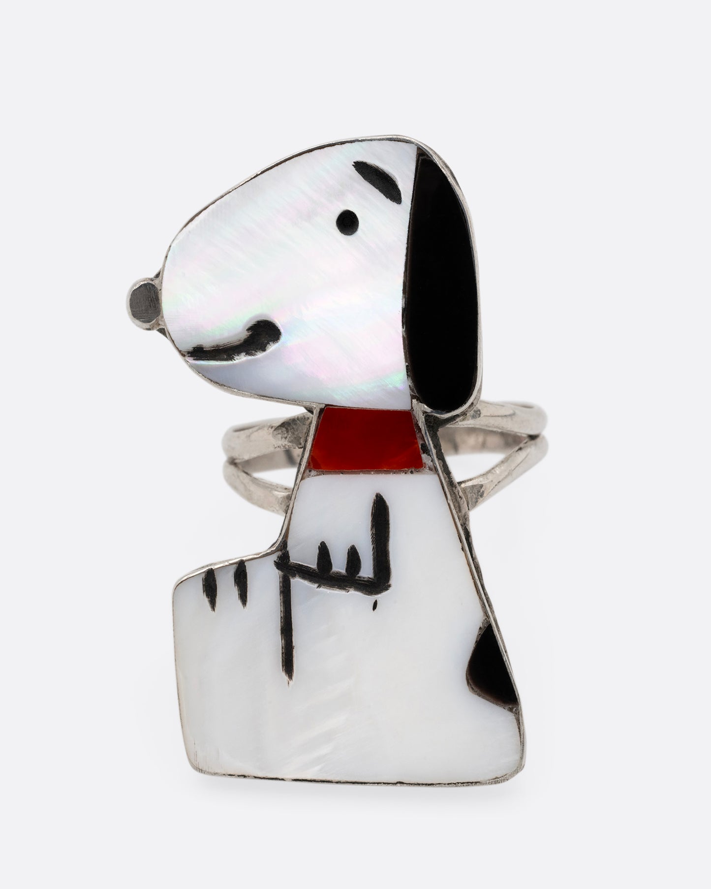A silver Zunitoon style Snoopy ring made of iridescent mother of pearl and coral inlay. Shown from the front.