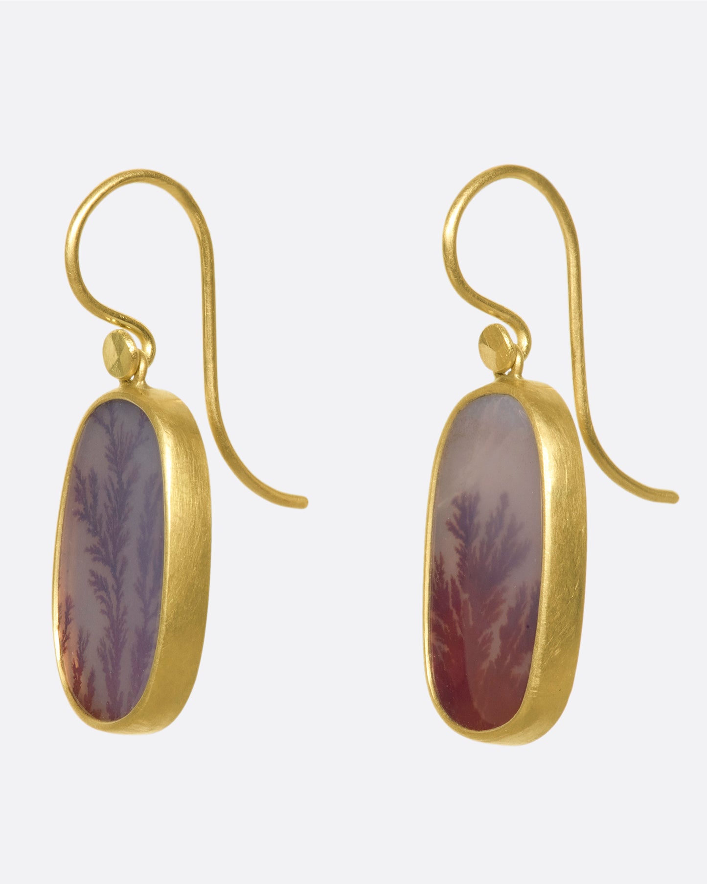 A pair of 18k gold drops with oval fiery dendritic agate stones. The tree-like occlusions swim in rosy pink light, adding a warm, glowing effect.