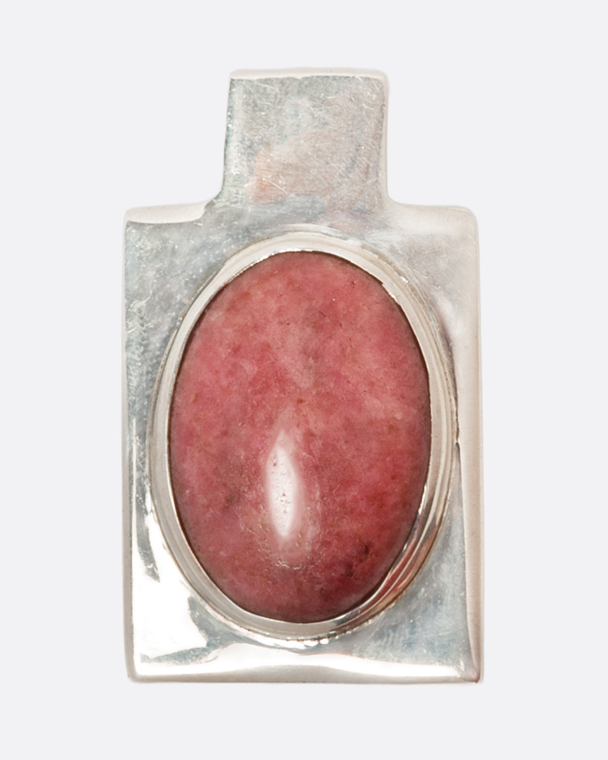 A sterling silver rectangular pendant with an oval pink stone cabochon. Shown from the front.
