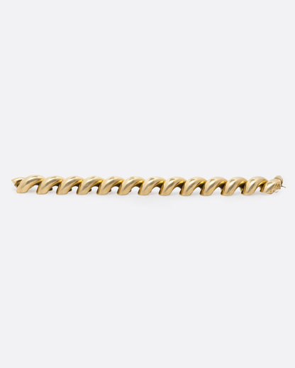 Vintage yellow gold twist bracelet, side view of the bracelet laid flat, showing the twisted profile