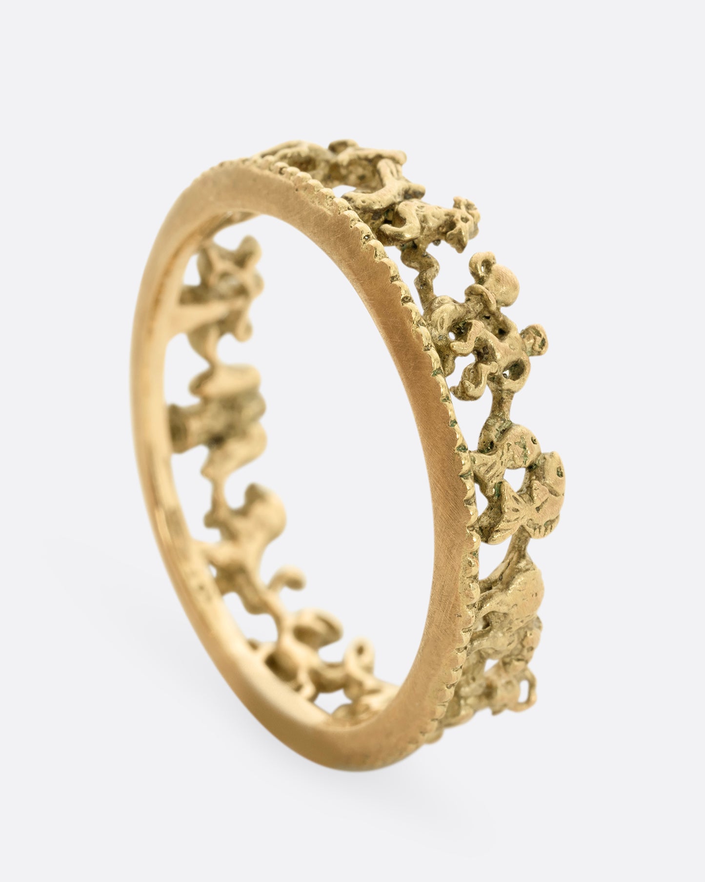 A yellow gold ring with every zodiac character around the entire band. Shown from the side, standing up.