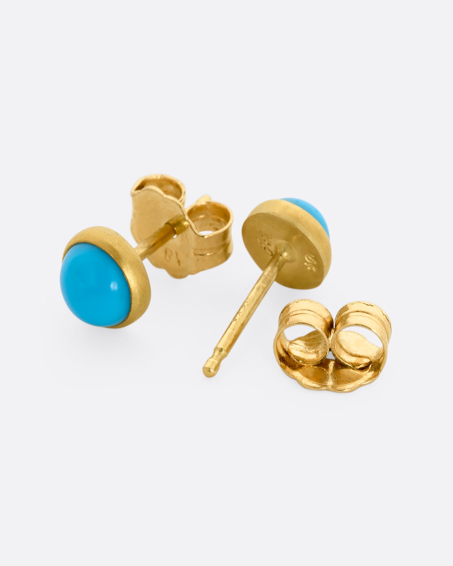 A pair of yellow gold turquoise cabochon stud earrings. View from the front and the back, alternating.