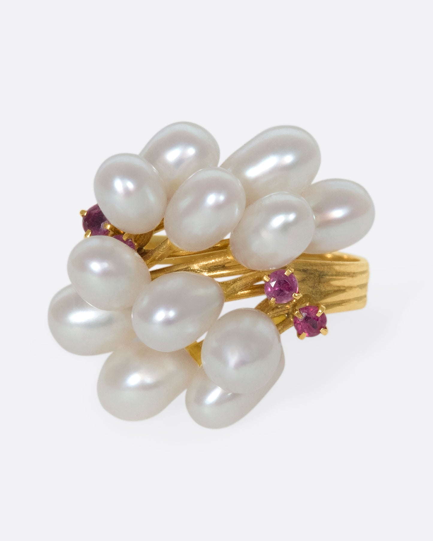 A 14k gold and pearl pussy willow ring with pink sapphire accents. Silky pearls wave across your finger like blossoms, adding beautiful dimension to your finger.