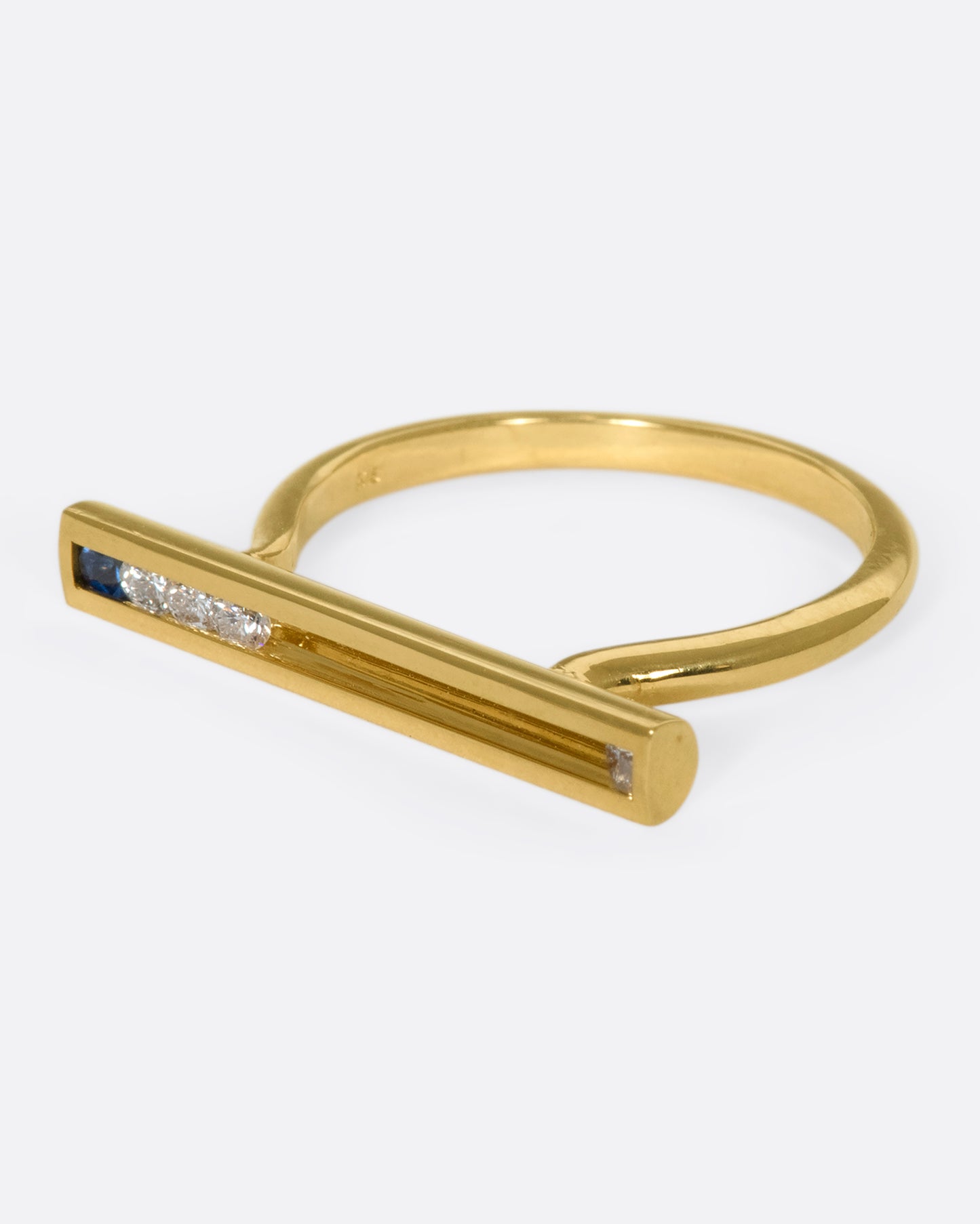 A flat-face ring with blue sapphires and diamonds that glide across an 18K gold bar.