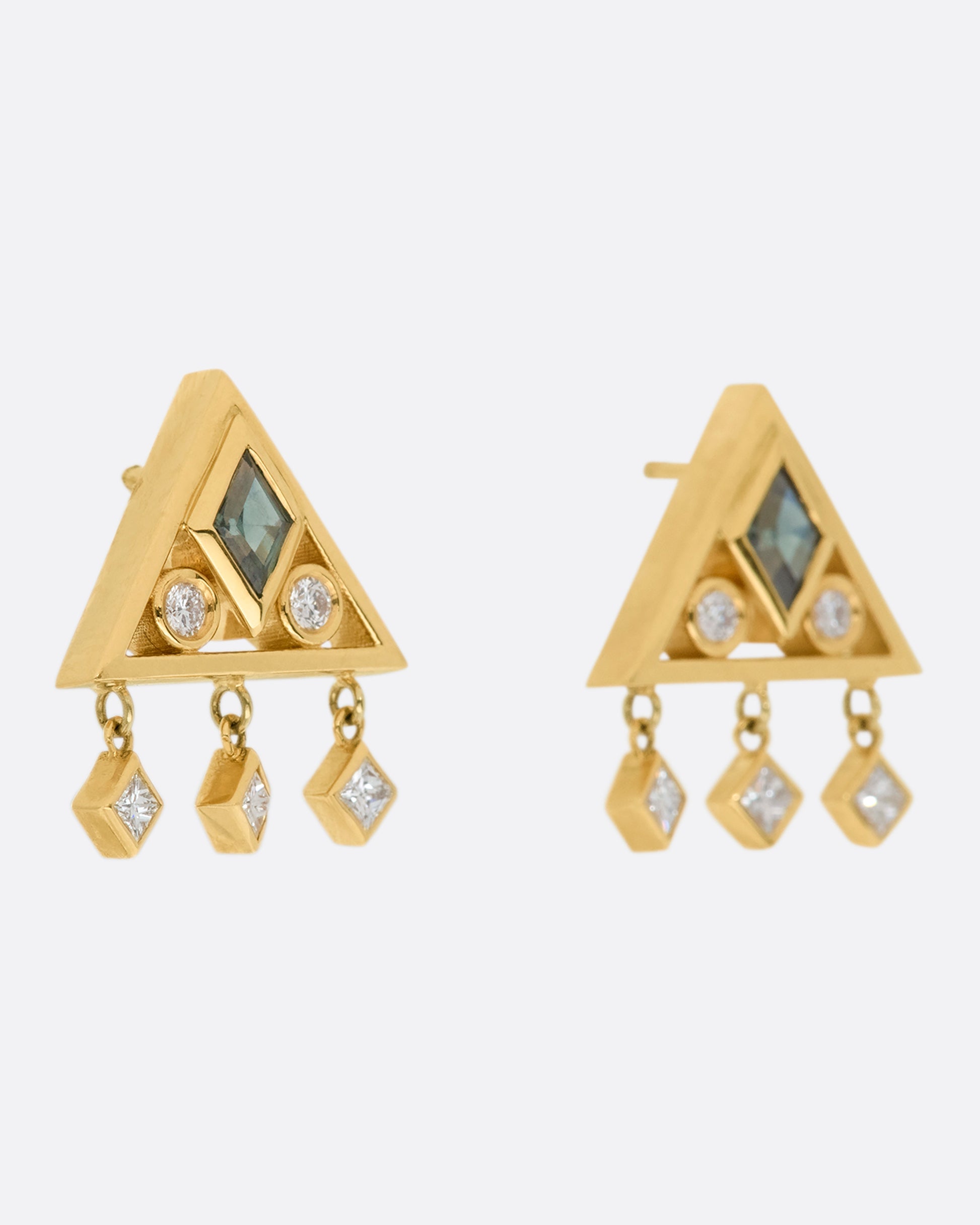 A gorgeously geometric pair of 14k gold triangle studs with teal sapphire lozenges and diamond accents