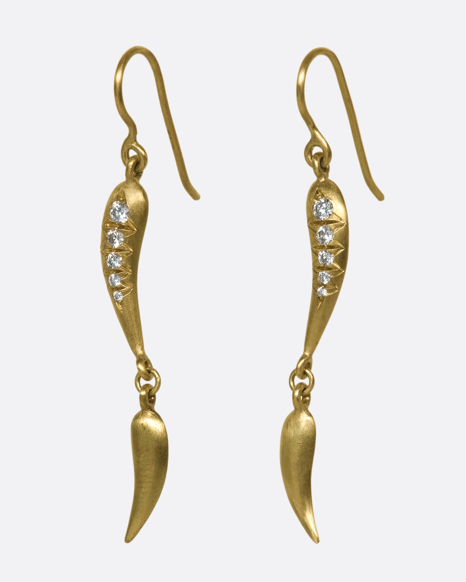 A side view of gold drop earrings with 2 curved segments on each side, two of which have 5 diamonds.