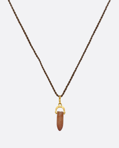 A stunning pre-Columbian carnelian bullet pendant suspended in 22k gold from a lengthy, twisted brown chord