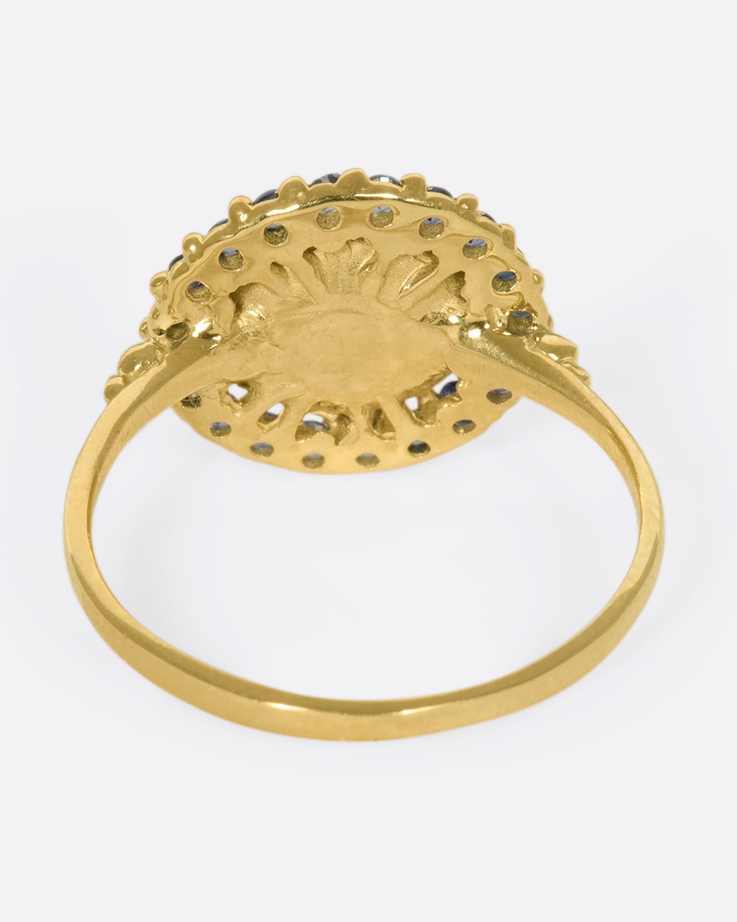 A 14k gold circle ring with a halo of ombré blue sapphires