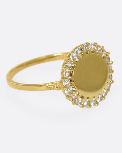 A 14k gold circle ring with a white diamond halo