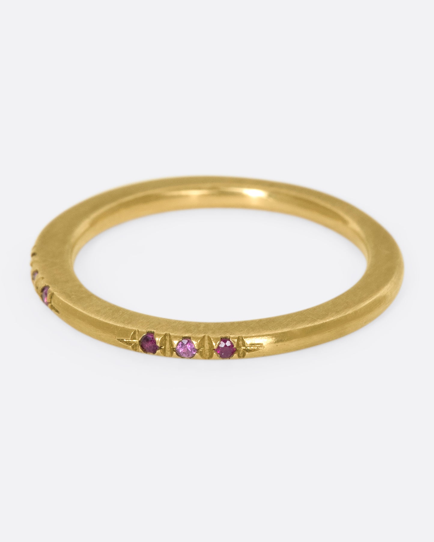 A 10k brushed gold band with rubies and pink sapphires