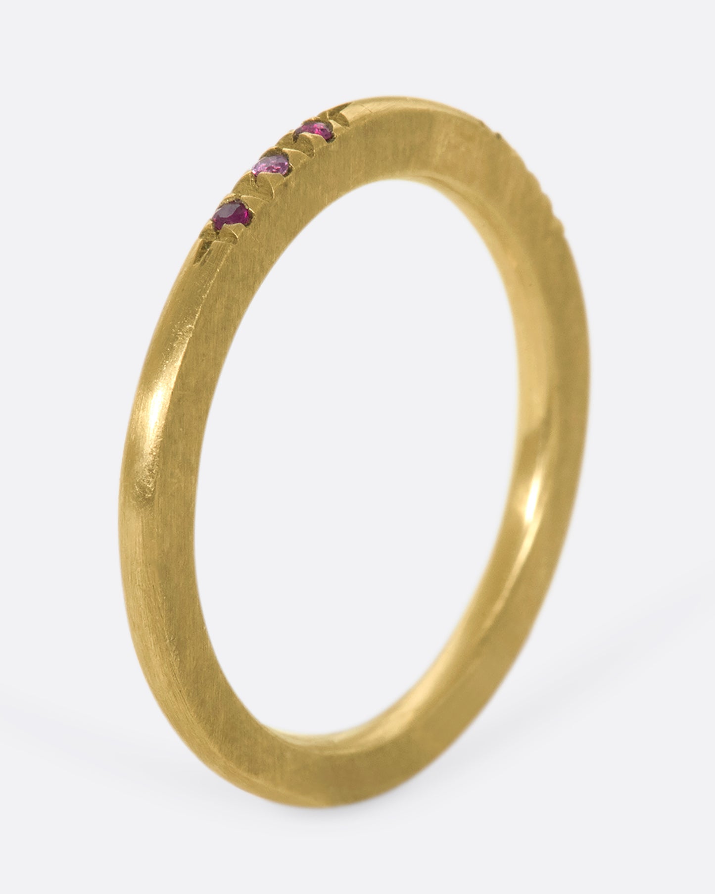 A 10k brushed gold band with rubies and pink sapphires