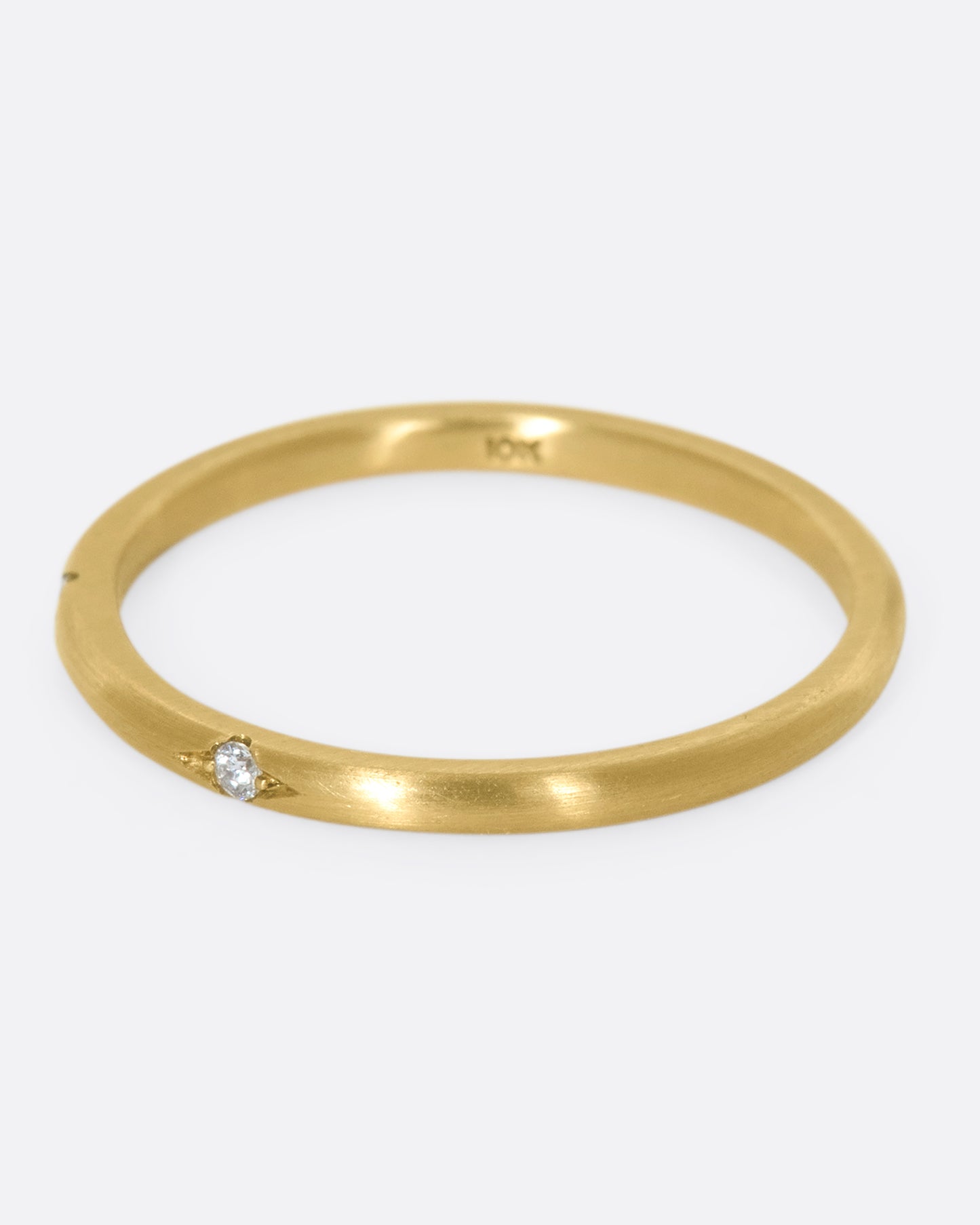 This 10k gold stacking ring features two flush-set white diamonds that sink into the soft gold band