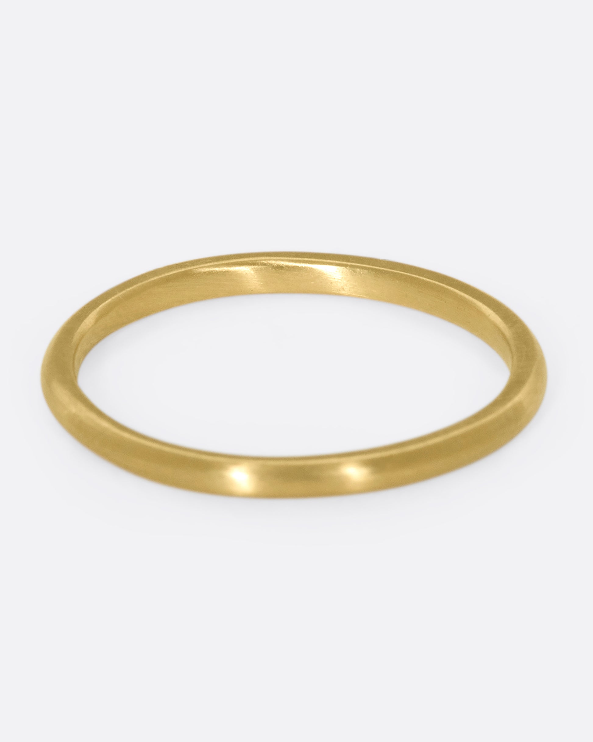 This 10k gold stacking ring features two flush-set white diamonds that sink into the soft gold band