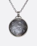 A platinum necklace with a moon intaglio carving bezel set and hanging from a cable chain. Shown from the front.