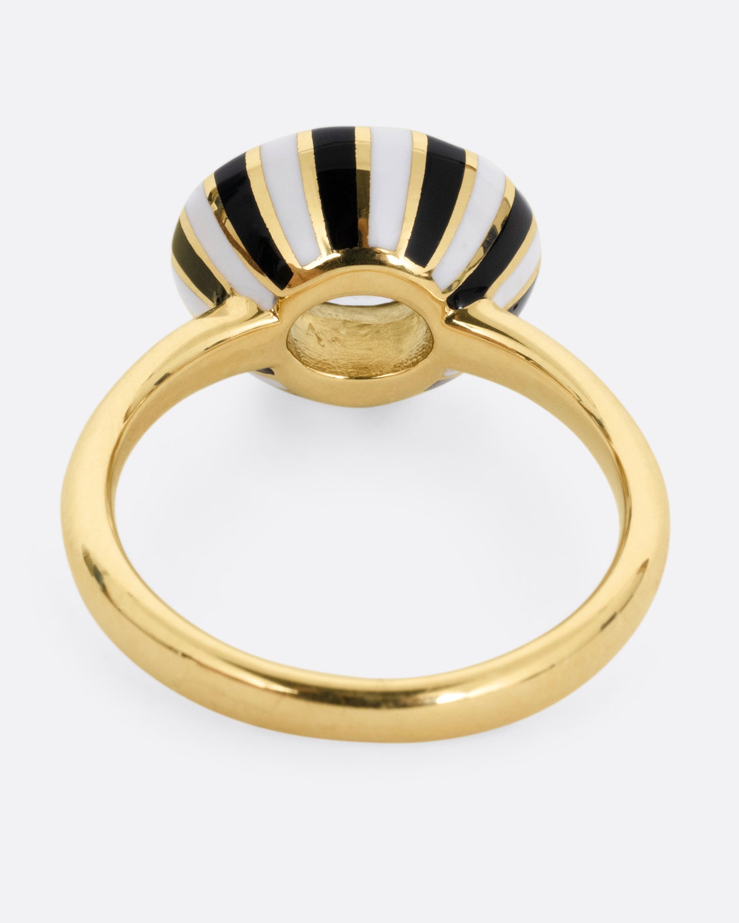 A yellow gold ring with an enamel checkerboard pattern around a green sapphire, shown from the back.