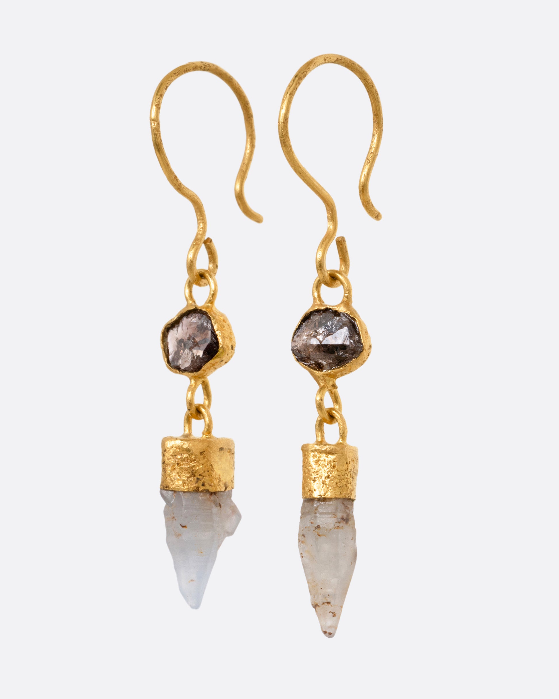 A pair of yellow gold drop earrings with Borneo diamonds and Sri Lanken sapphires, shown from the side.