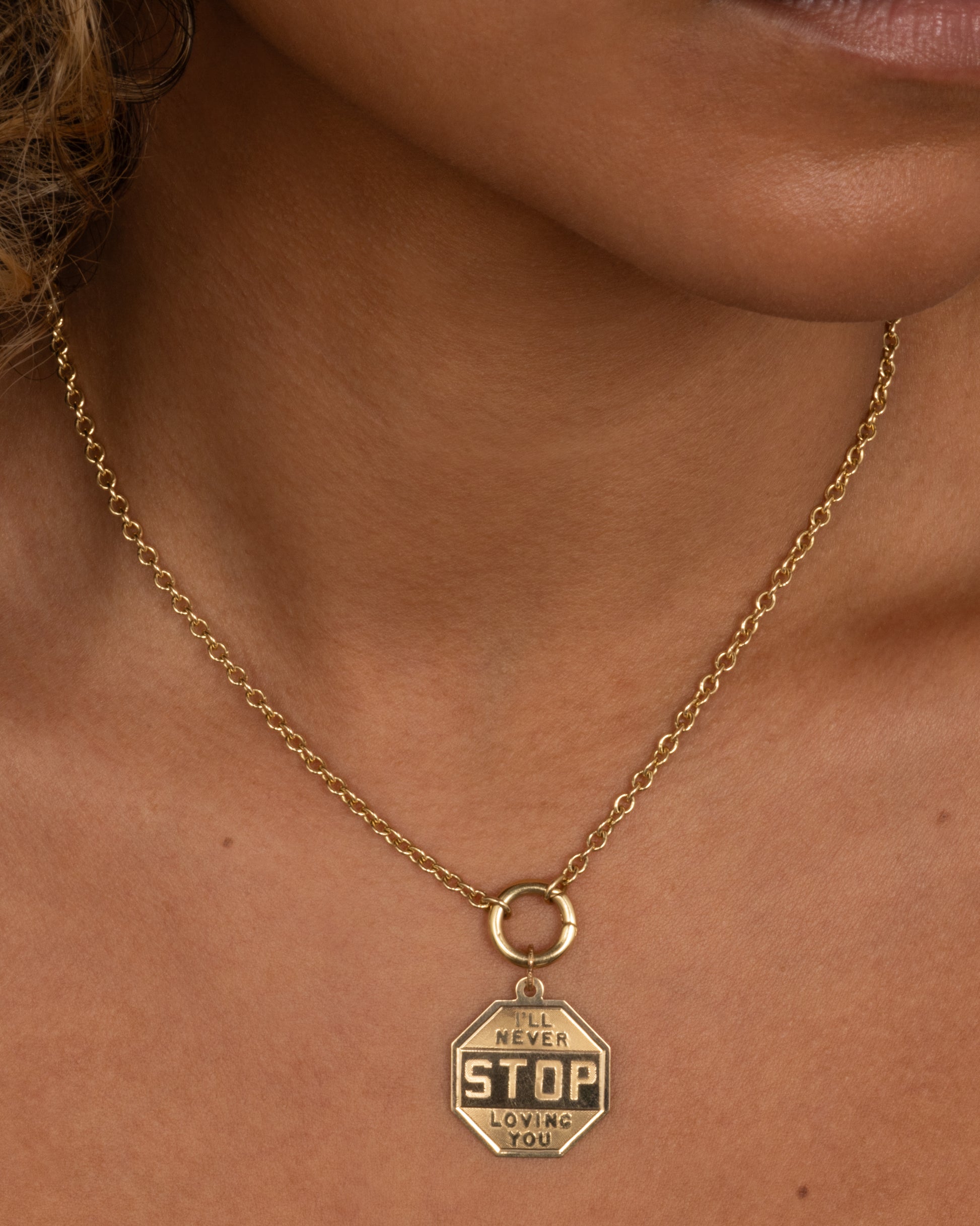 A yellow gold octagon shaped pendant with an engraved 'Happy Birthday 1964' on the back. Shown worn