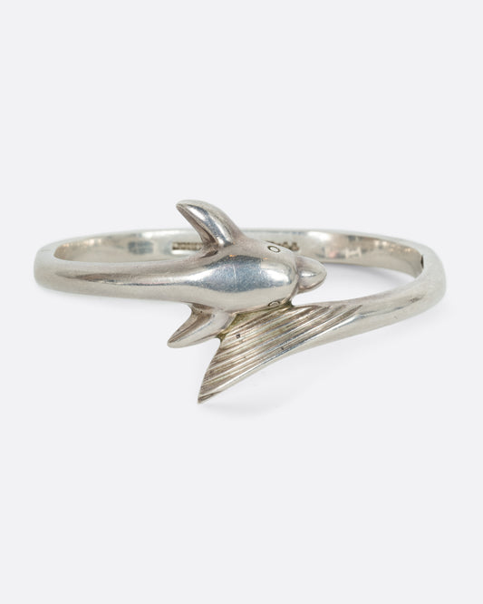 A sterling silver dolphin wrap bracelet. Shown from the front.