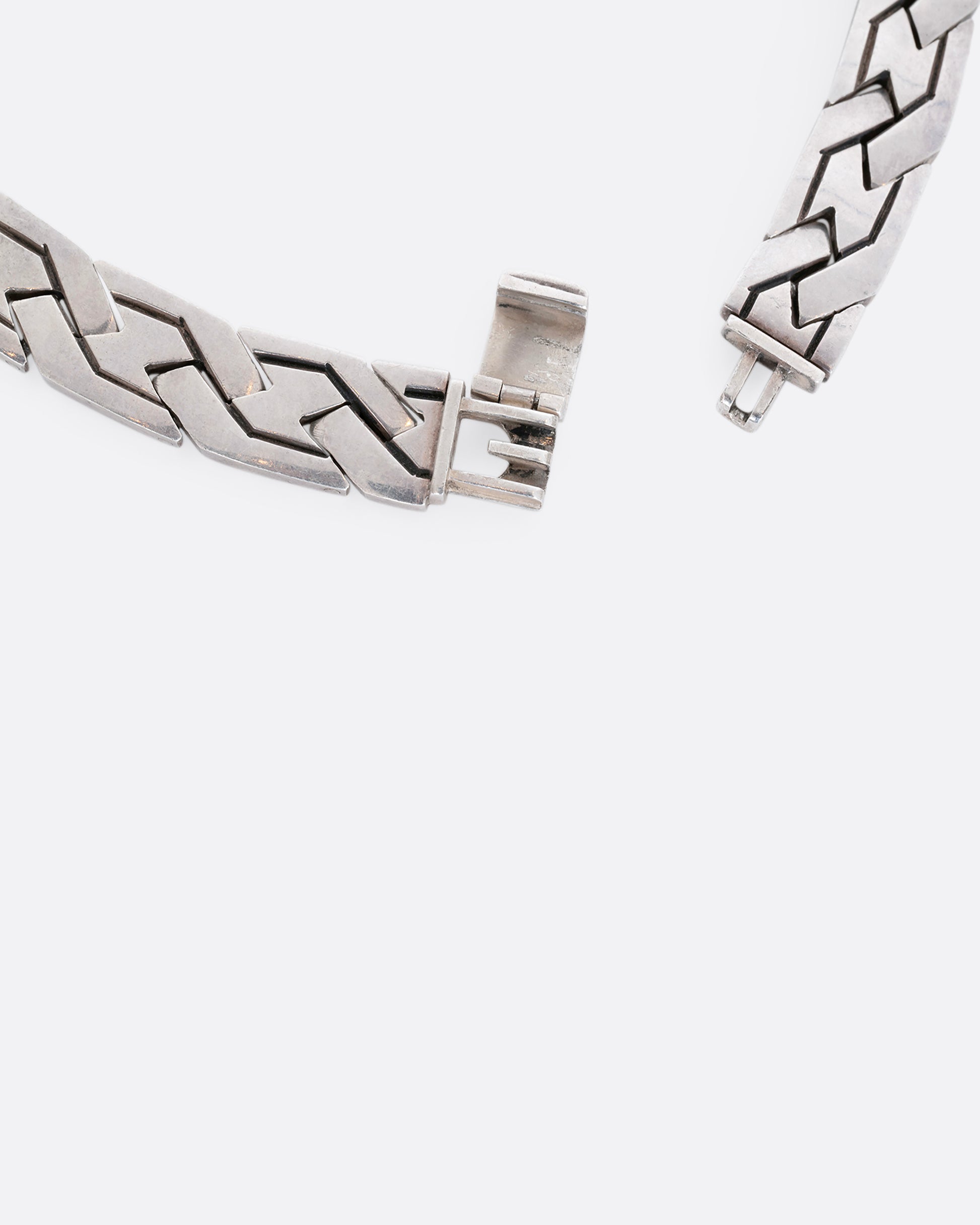 A flat woven link sterling silver necklace. A close up of the closure.