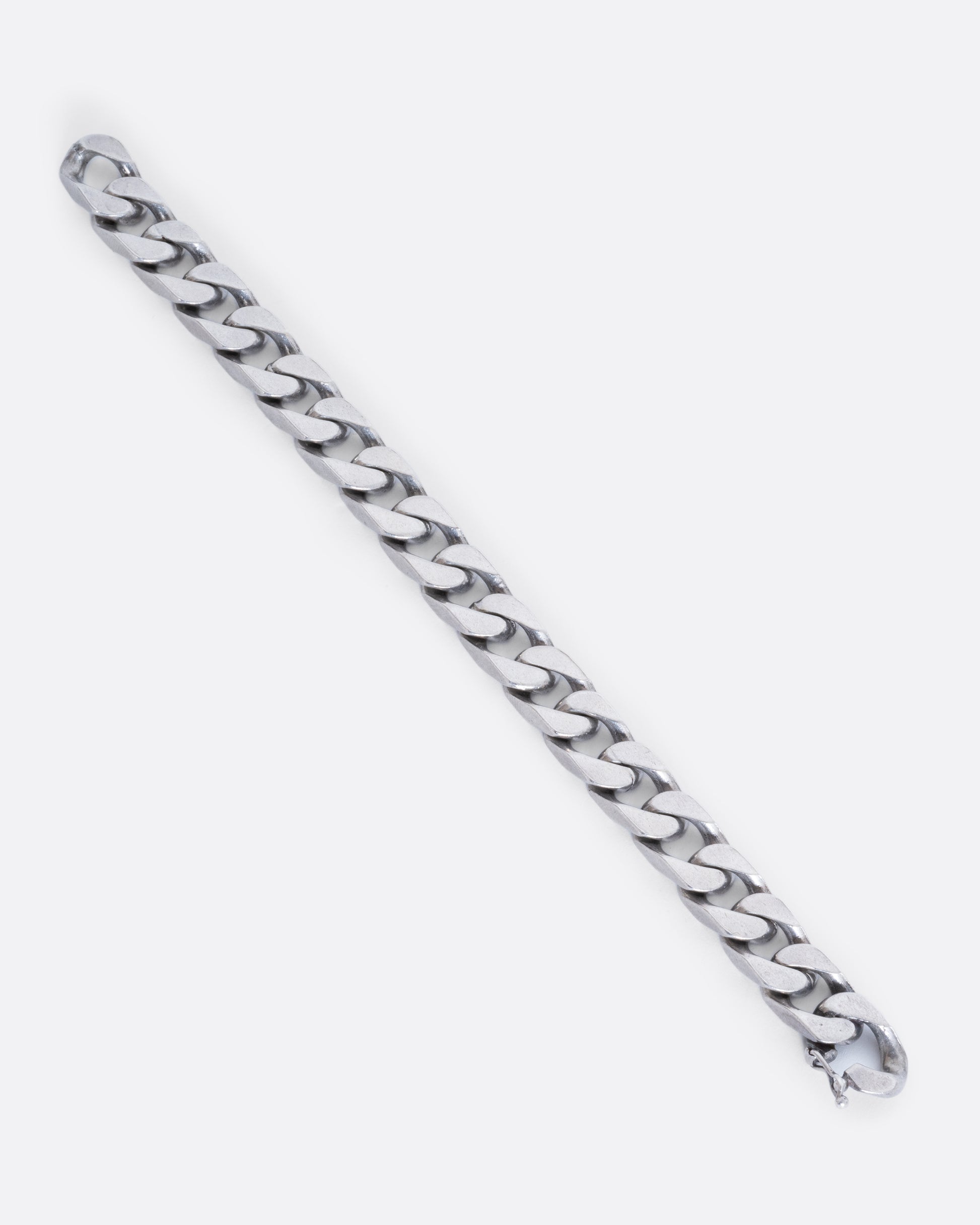 A chunky flat curb chain bracelet. View of the full bracelet, laying flat.