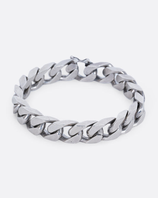 A chunky flat curb chain bracelet. View from the front, closed.