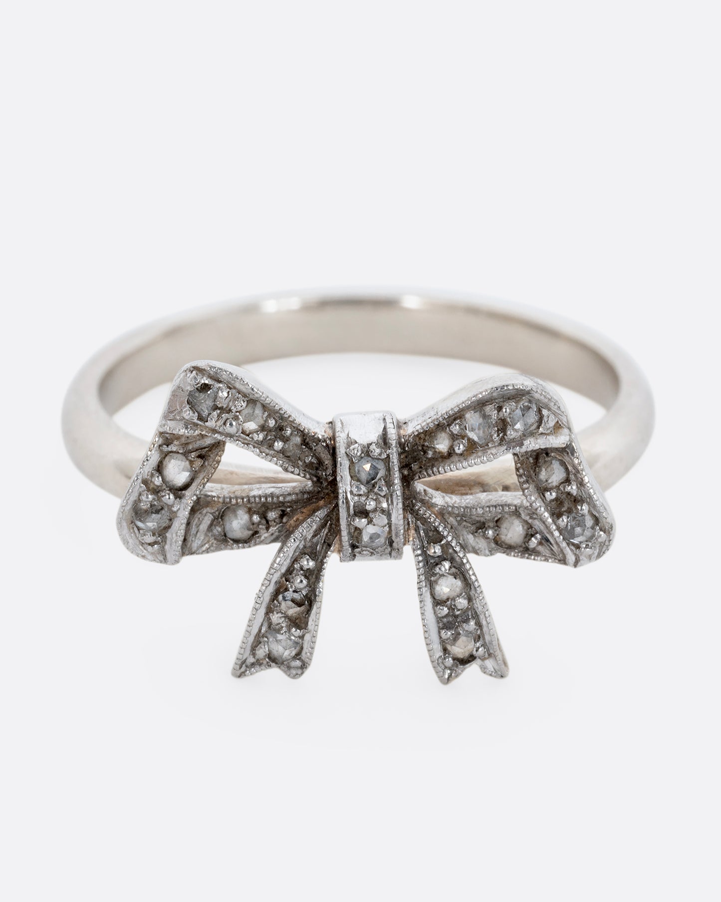 A white gold bow ring with diamonds. View from the front.