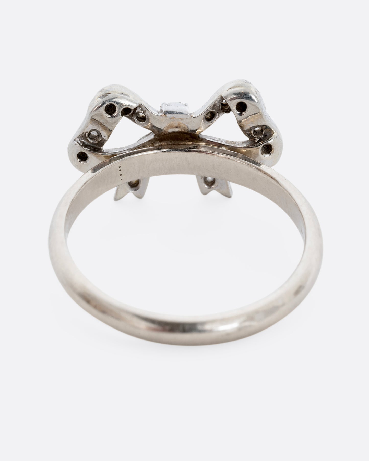 A white gold bow ring with diamonds. View from the back.