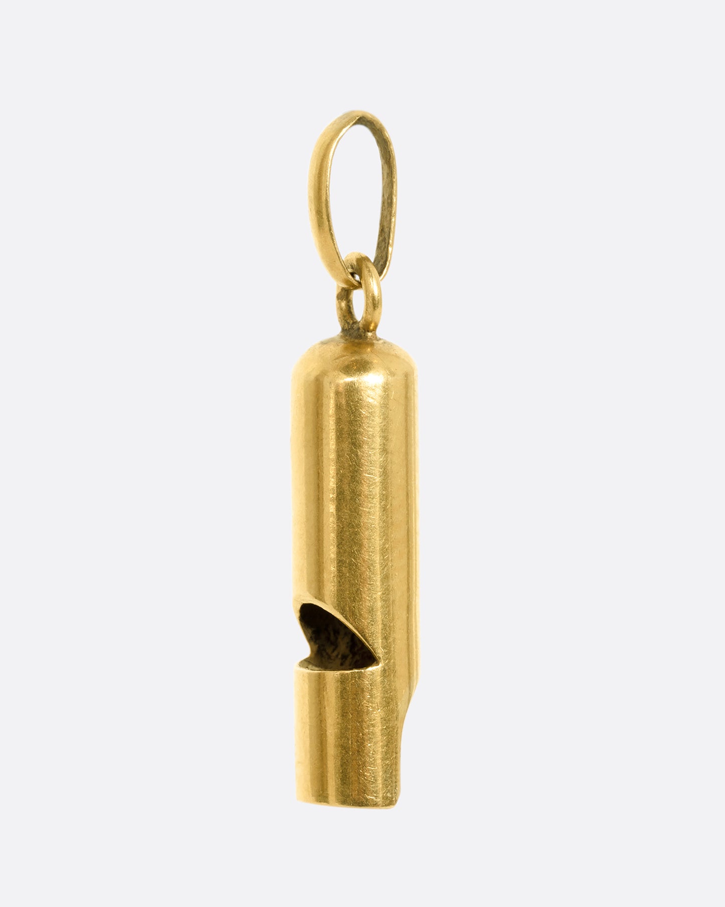 A yellow gold whistle charm. View from the side.