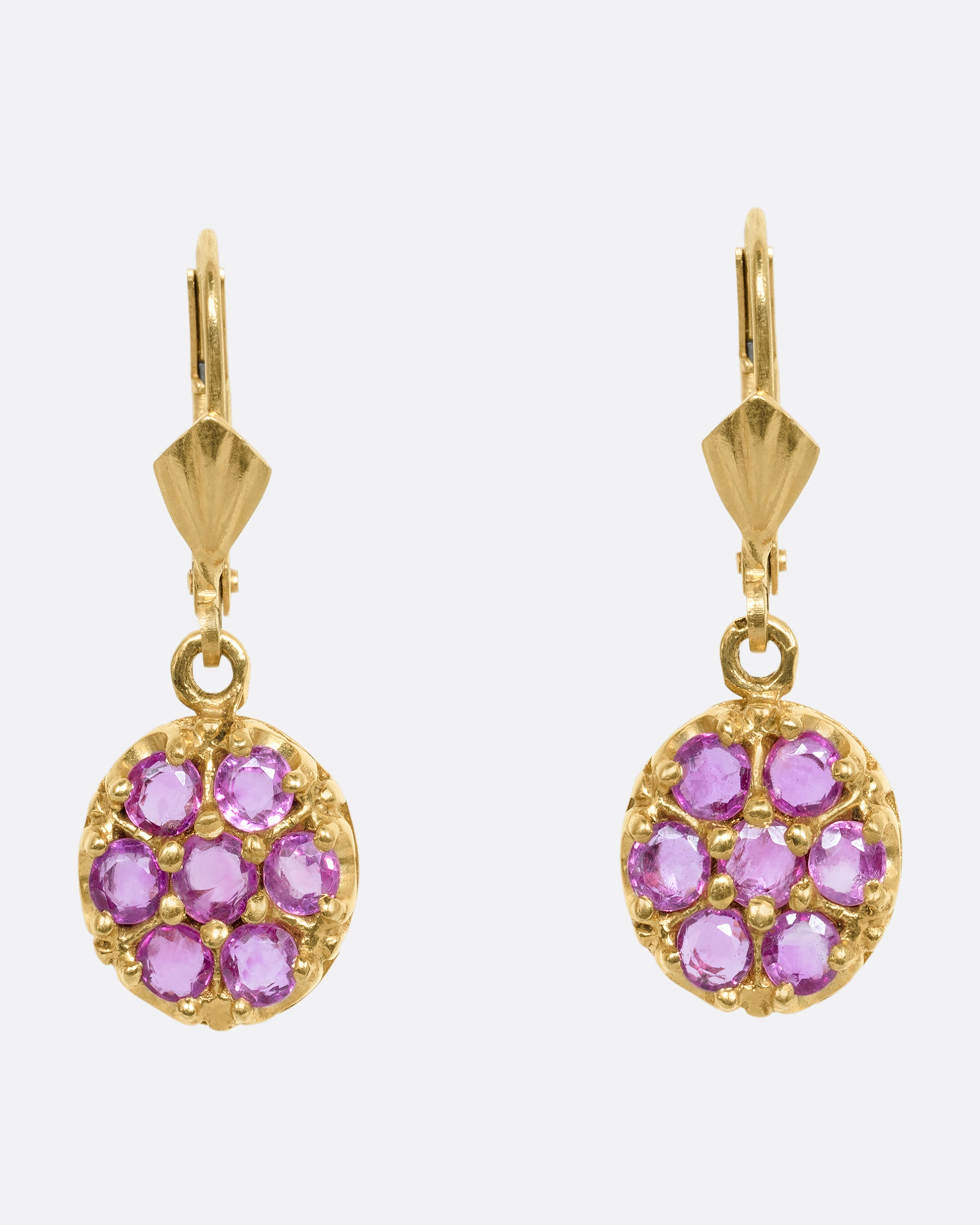 Yellow gold leverback drop earrings with a pink sapphire flower on each. View from the front.