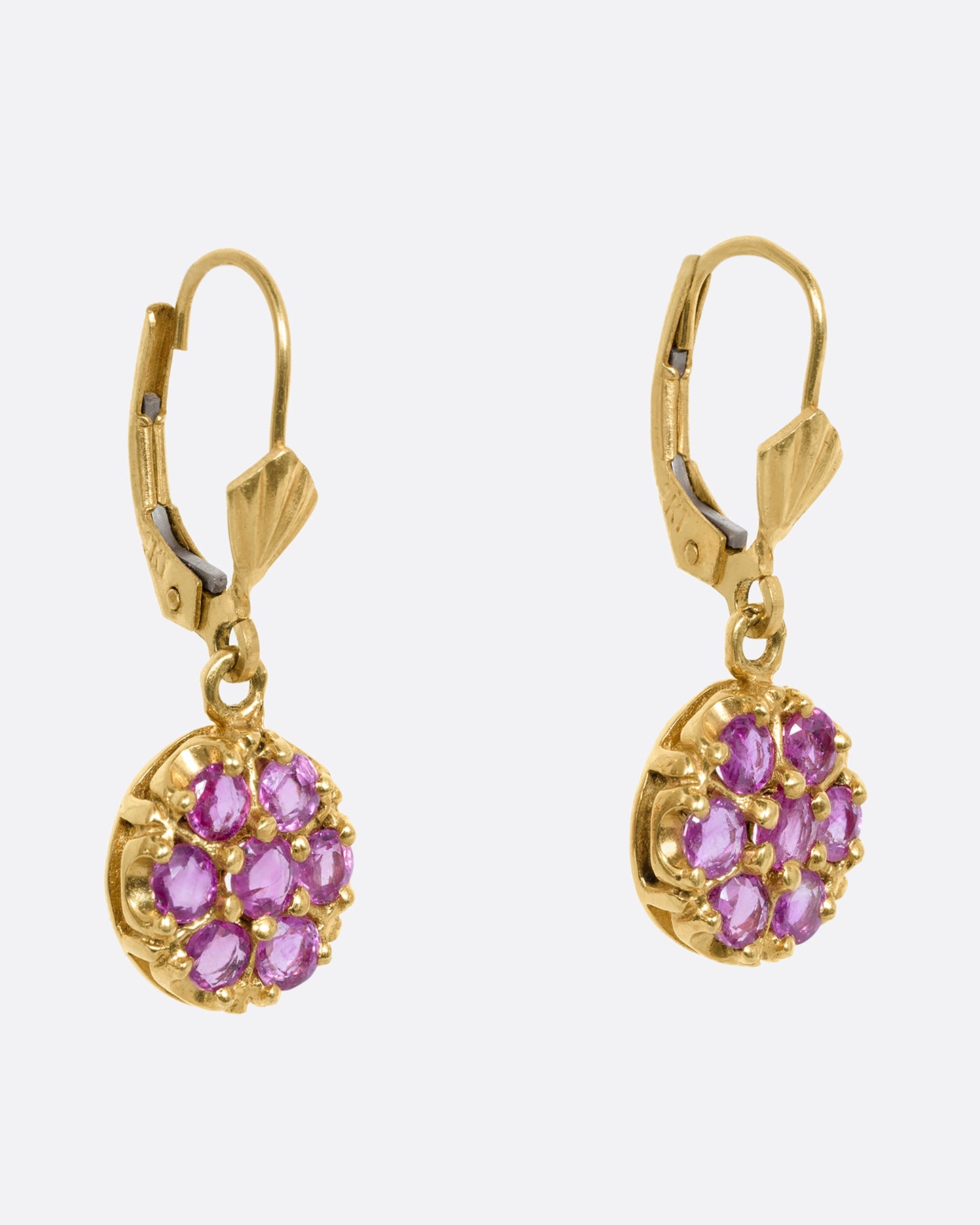 Yellow gold leverback drop earrings with a pink sapphire flower on each. View from the side.