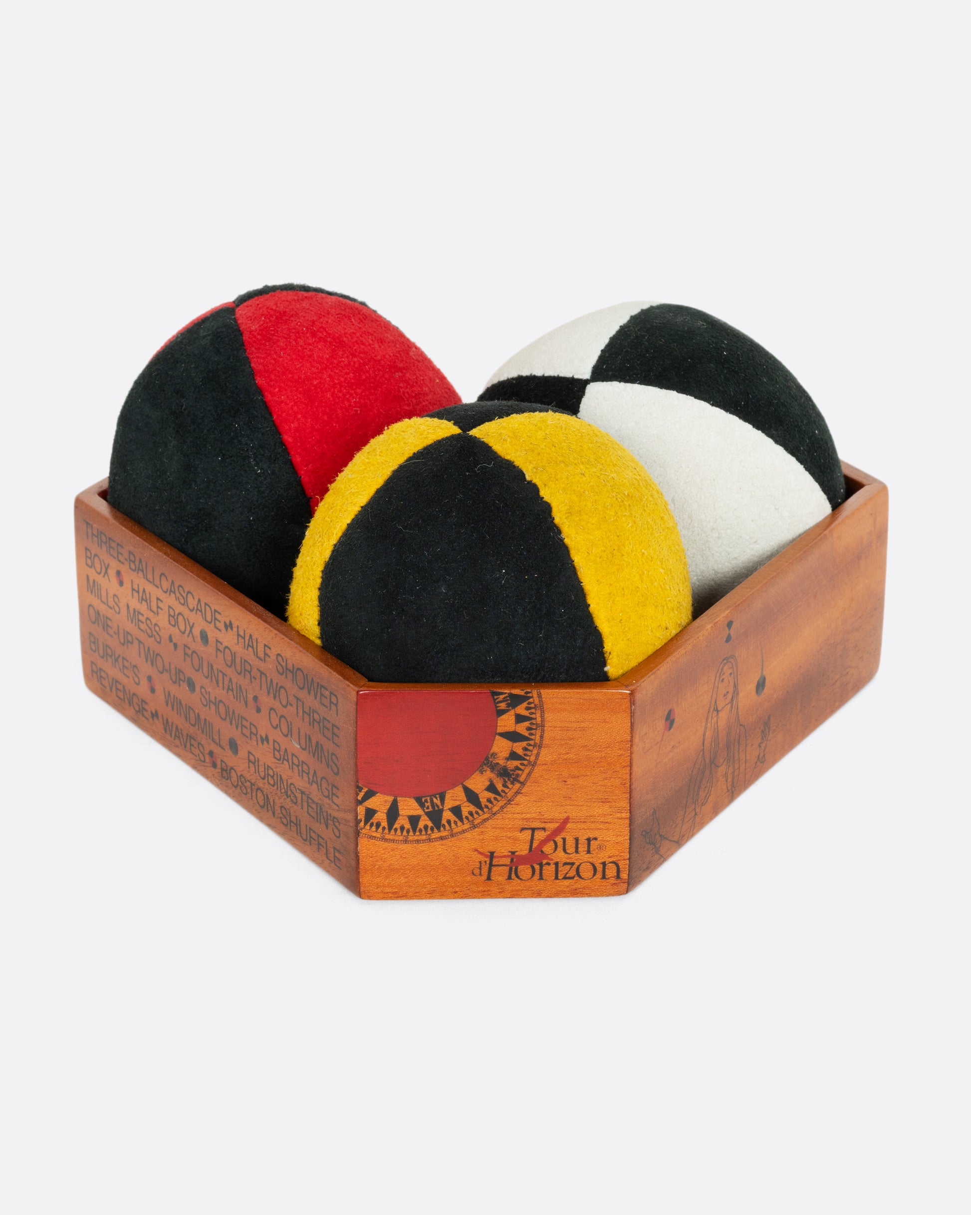 A set of three juggling balls in a wooden box. 