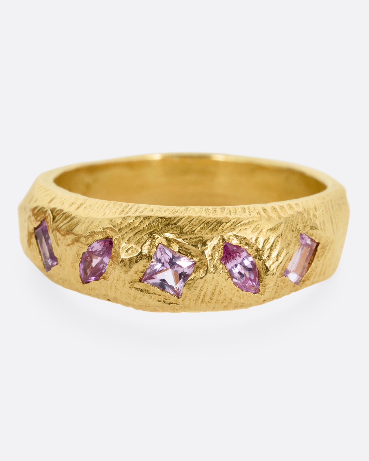 A yellow gold band with five pink sapphires, shown from the front.