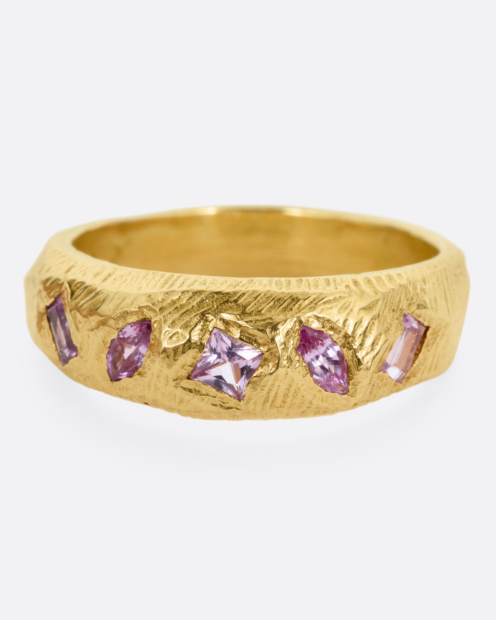 A yellow gold band with five pink sapphires, shown from the front.