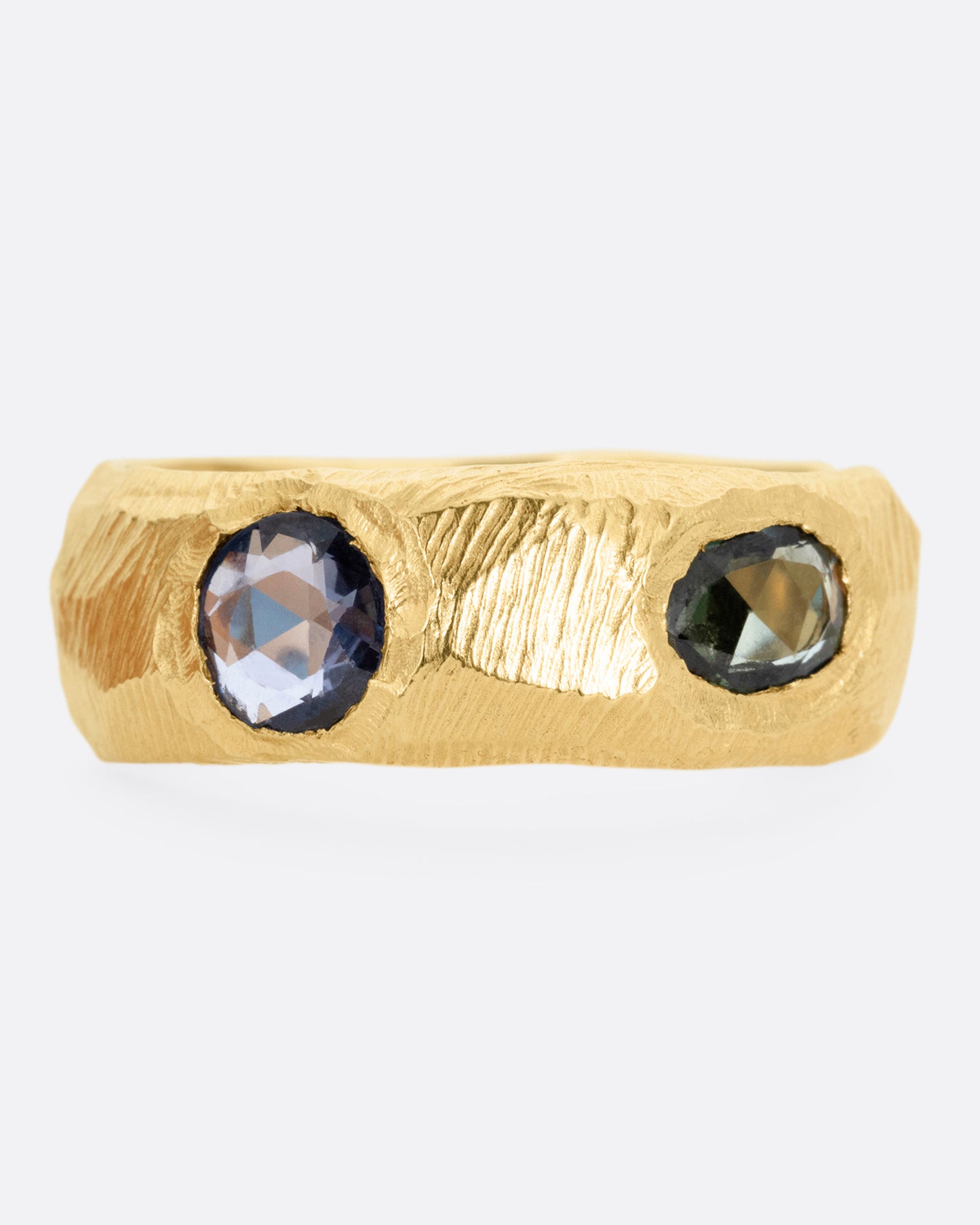 A yellow gold ring with rose cut sapphires in cool blues and greens, shown from the front.