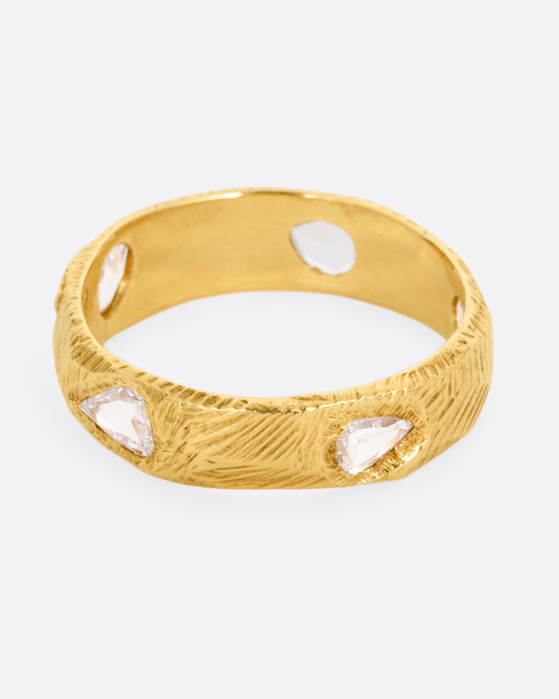 A yellow gold ring with five freeform rose cut diamonds, shown from the front.